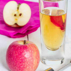 Apple juice freshly squeezed in glass on wood